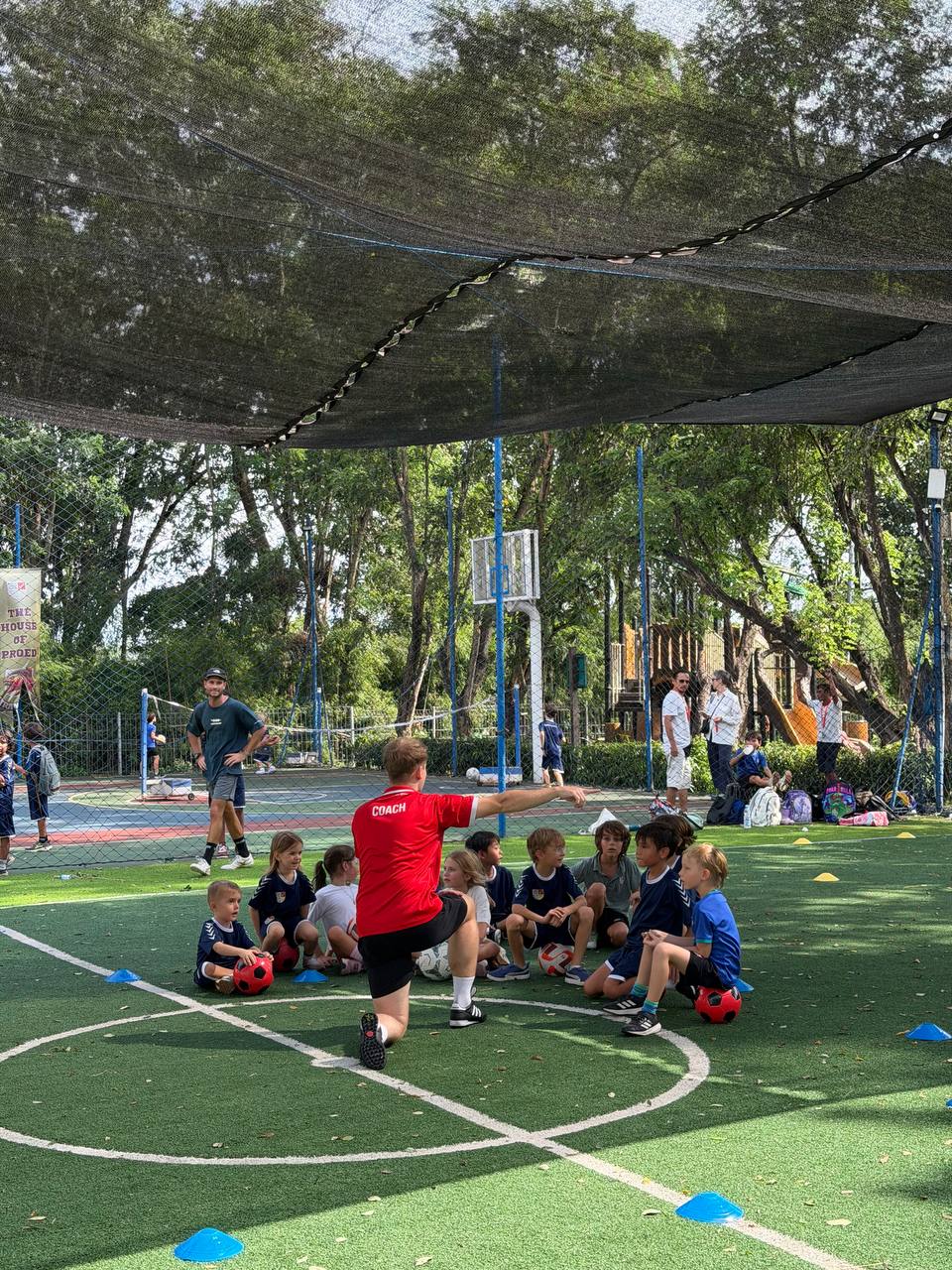 UNITY coach briefing a group of players on an outdoor pitch