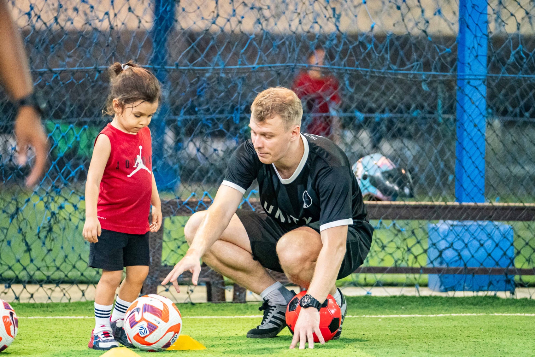 UNITY coach demonstrating an exercise to a young player